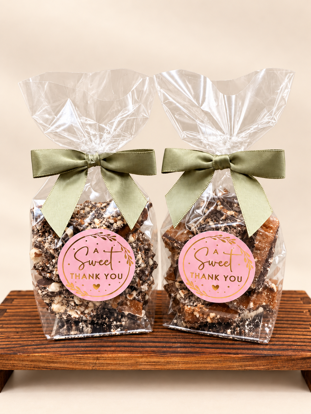 Wedding favors in 3 oz clear bags with custom stickers and sage green bows. 