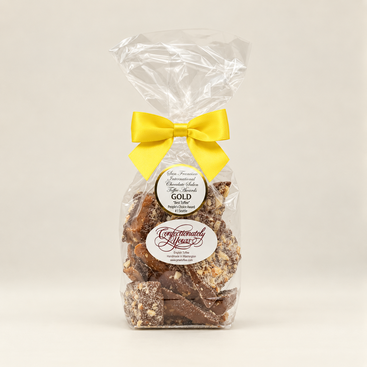 Half-pound Confectionately Yours milk chocolate almond English toffee in a clear gift bag with yellow bow