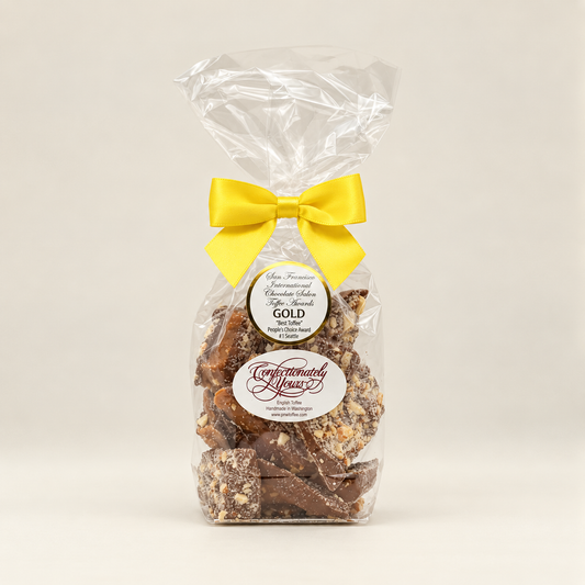 Half-pound Confectionately Yours milk chocolate almond English toffee in a clear gift bag with yellow bow