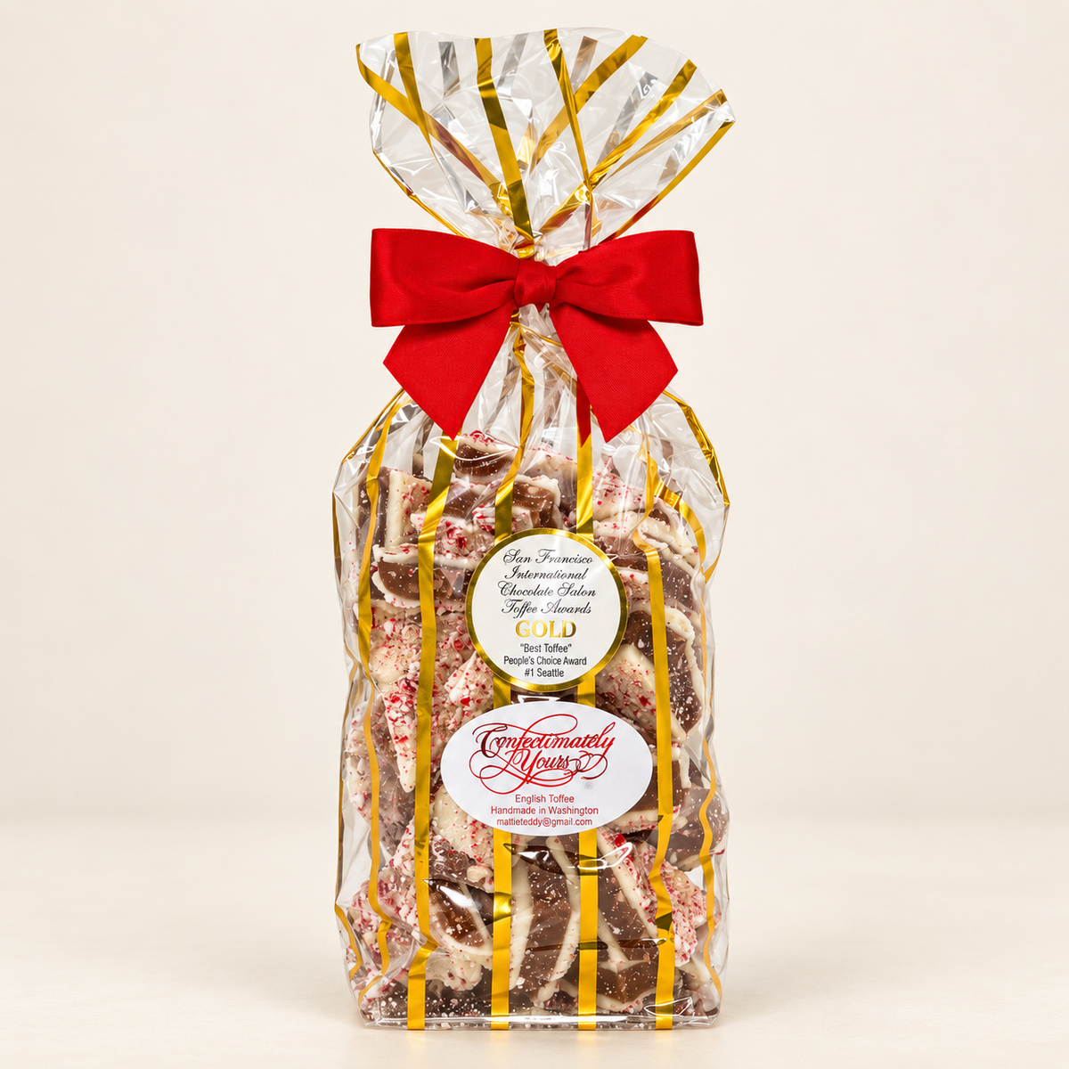 Confectionately Yours one-pound white chocolate peppermint English toffee in a festive holiday gift bag with red bow