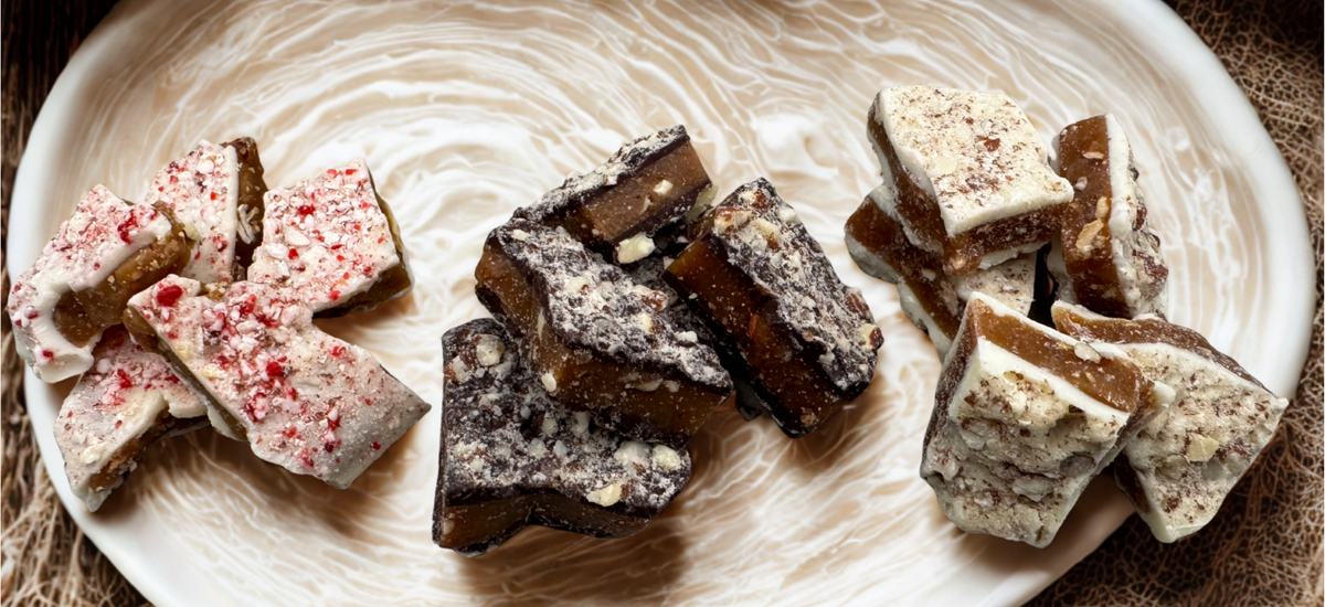 Dark chocolate almond, White Chocolate Peppermint with almond and white chocolate almond English toffee pieces displayed on an ivory serving tray