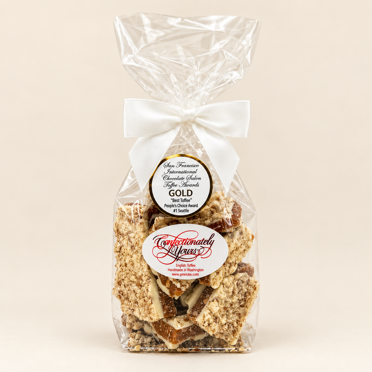 Half-pound Confectionately Yours white chocolate almond English toffee in a clear gift bag with white bow